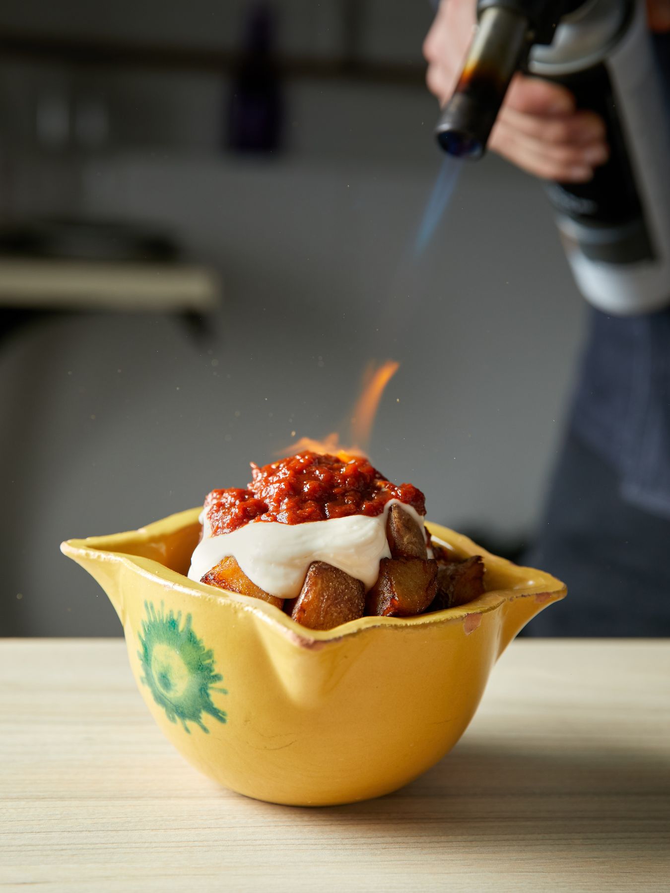 Bravas de l’Àpat en su cuenco amarillo, gratinadas con soplete