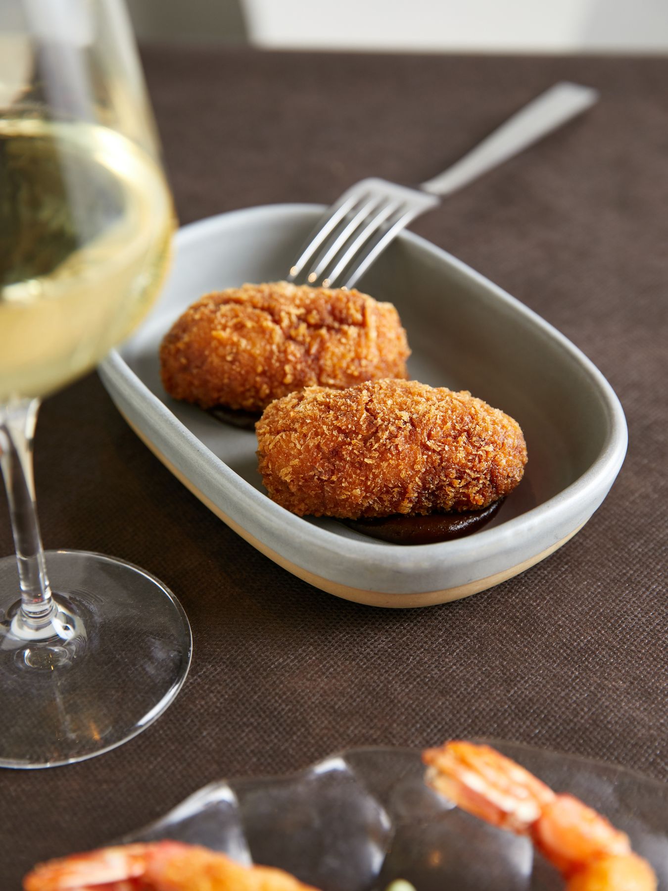 Croquetas caseras con una copa de vino blanco