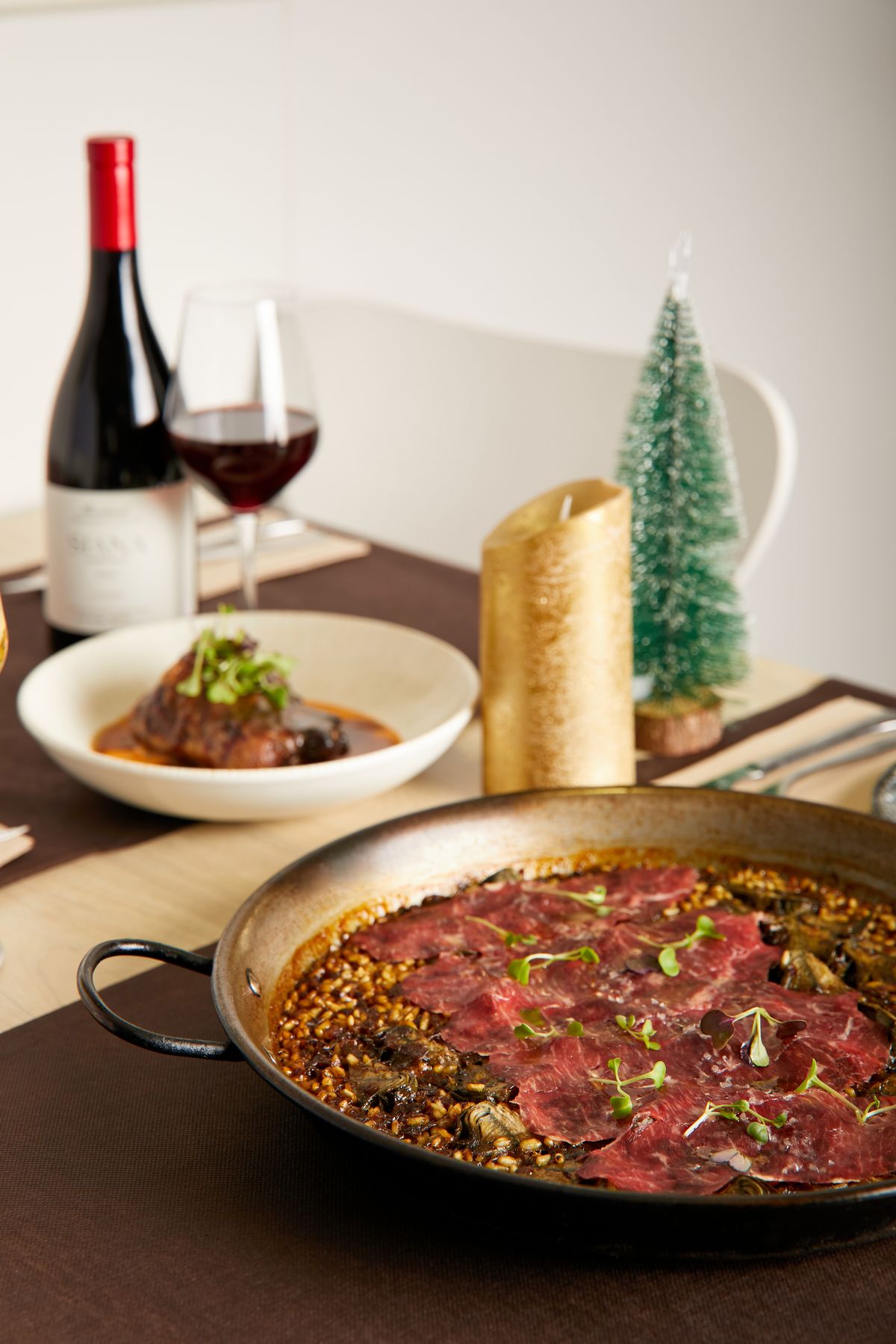 Mesa de Navidad con arroz, vino tinto y un pequeño árbol